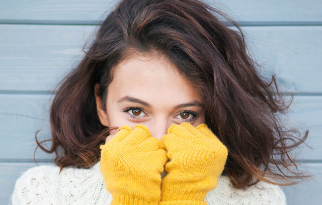 Frau mit Handschuhe lächelt