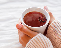 Frauenhände halten eine Tasse Tee