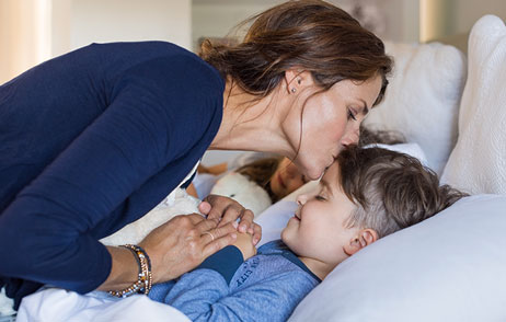 Parasomnien Mutter gibt ihrem Kind ein Gute-Nacht-Kuss