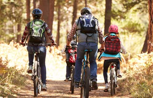 Familie auf den Rädern durch den Wald unterwegs