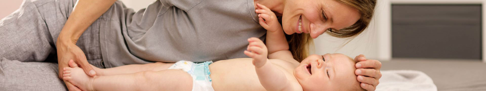 Mama spielt mit Baby und lacht