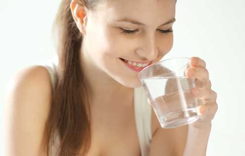 Frau trinkt ein Glas Wasser